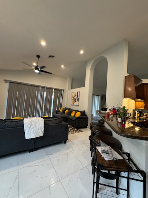 Dedicated cleaning professional meticulously tidying a West Palm Beach living room, reflecting Sunset Shine's commitment to excellence